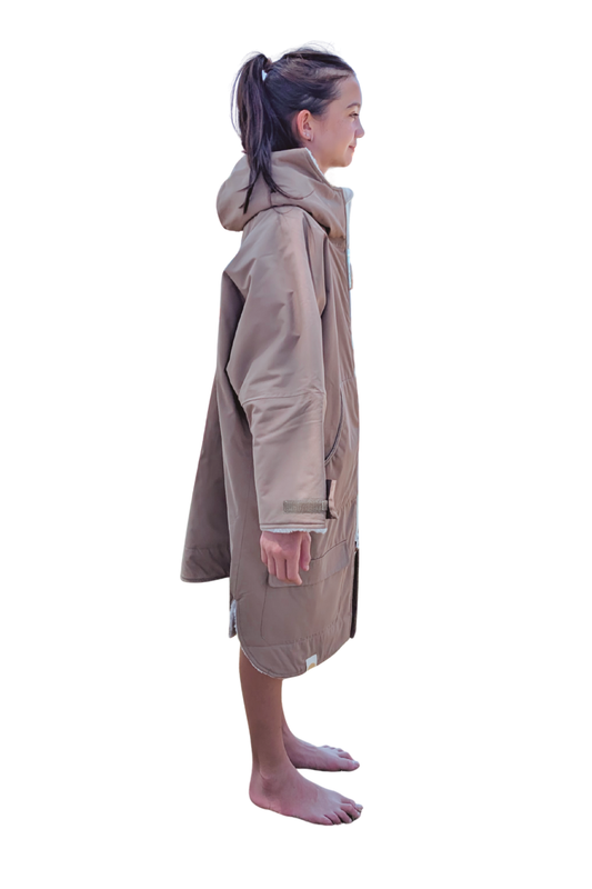 Child wearing a brown hooded changing robe on a white background