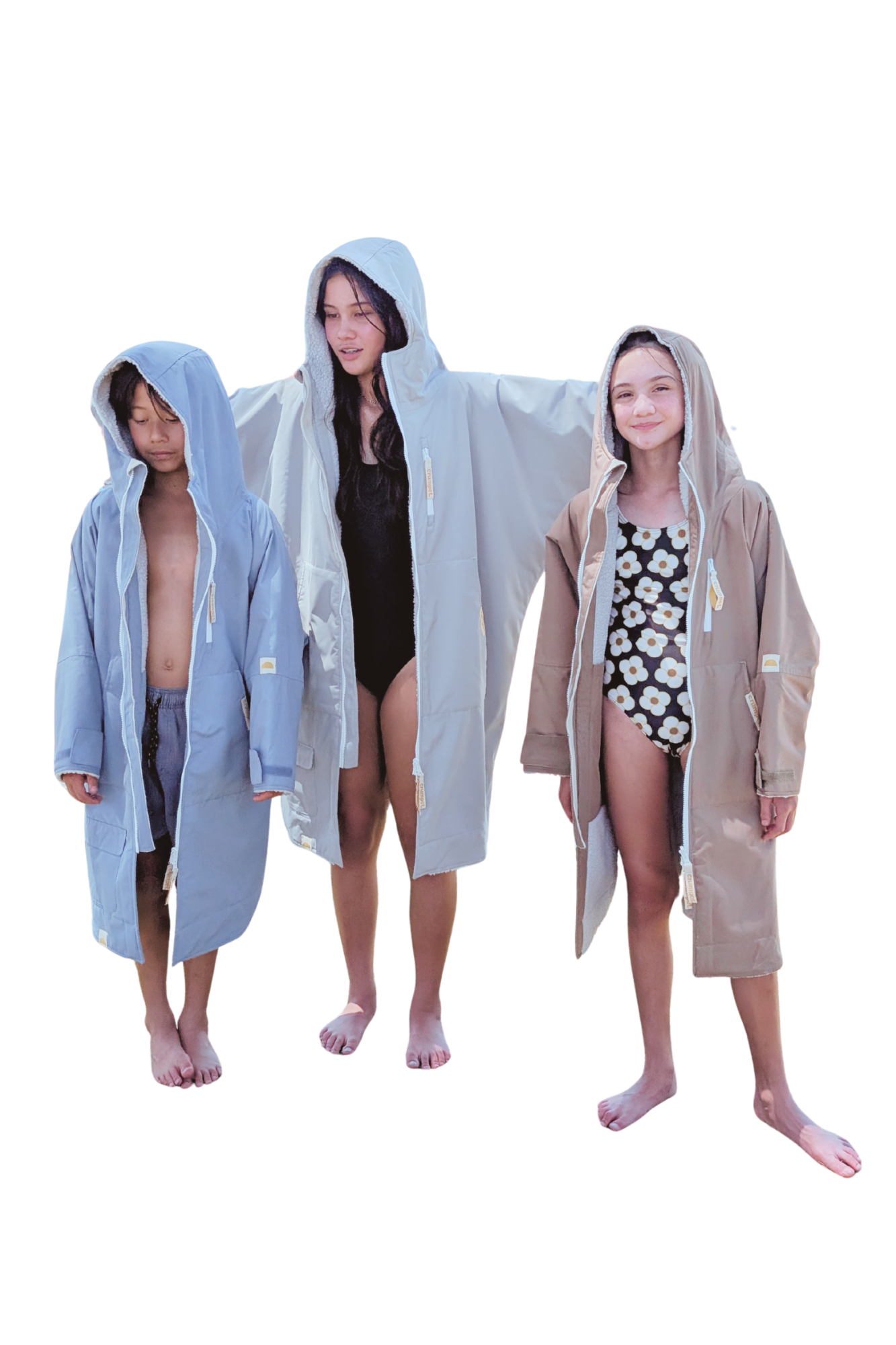 Three children wearing long, hooded changing robes on a white background