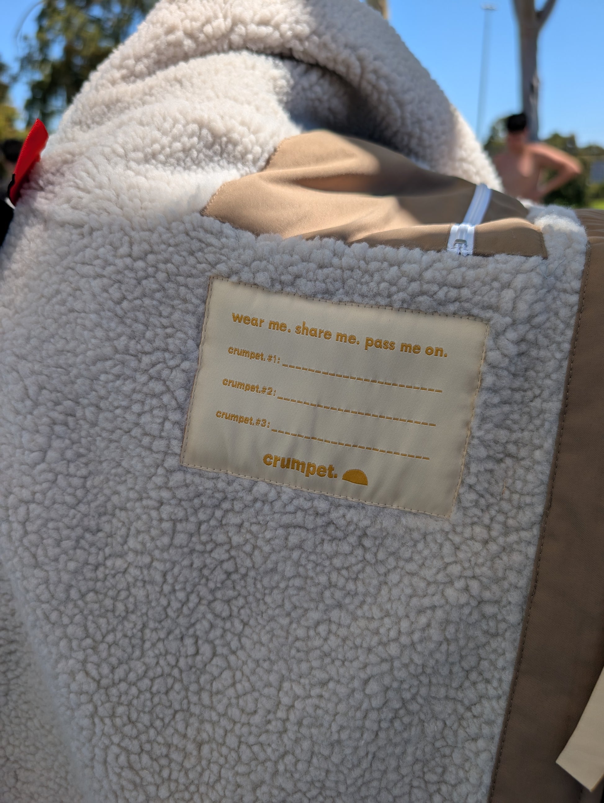 Close-up of a textured sherpa fabric with a hand me down brand name label on a sunny day.