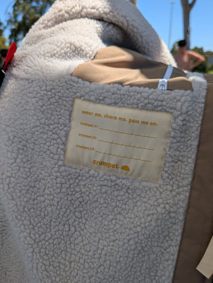 Close-up of a textured sherpa fabric with a hand me down brand name label on a sunny day.
