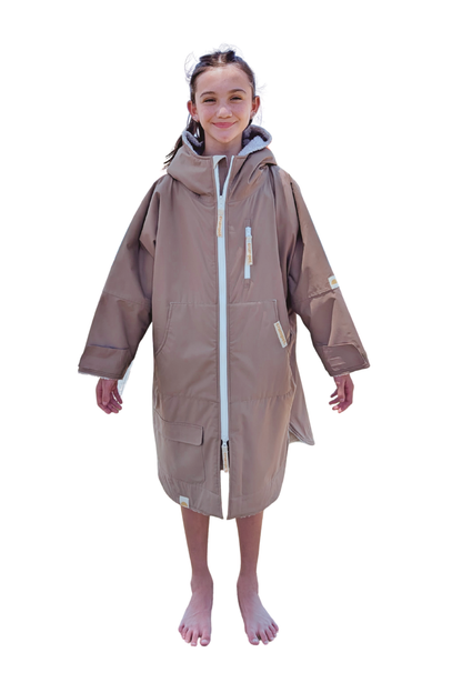 Child wearing a brown hooded changing robe on a white background