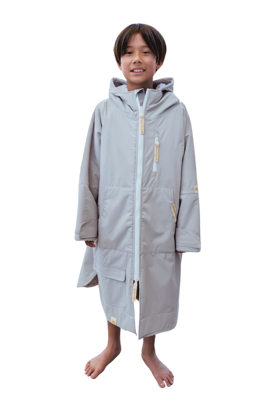 Child wearing a long grey hooded waterproof windproof jacket on a white background
